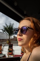 A woman in sunglasses gazes away.