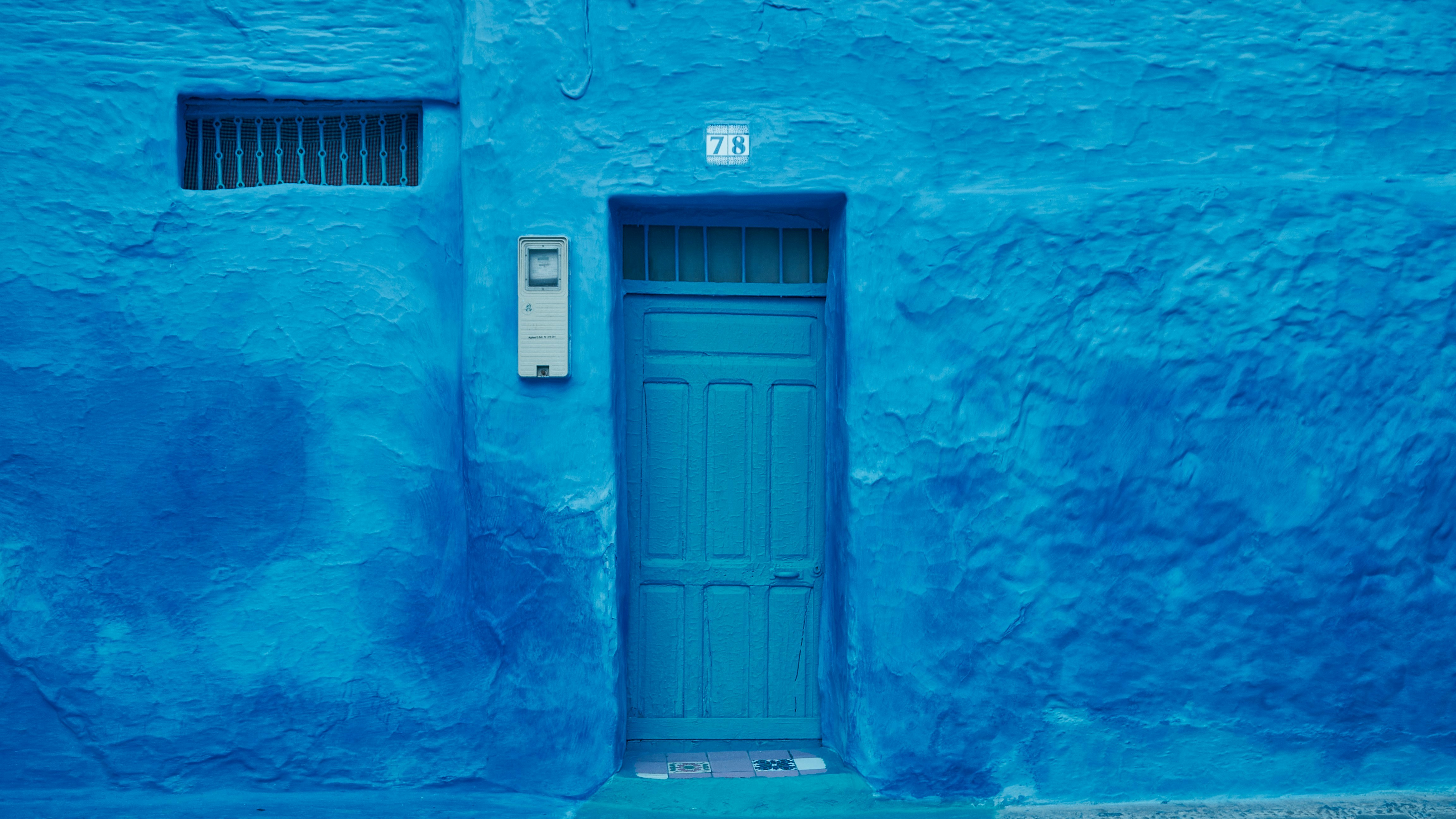 Una puerta y una pared azules en chefchaouen.