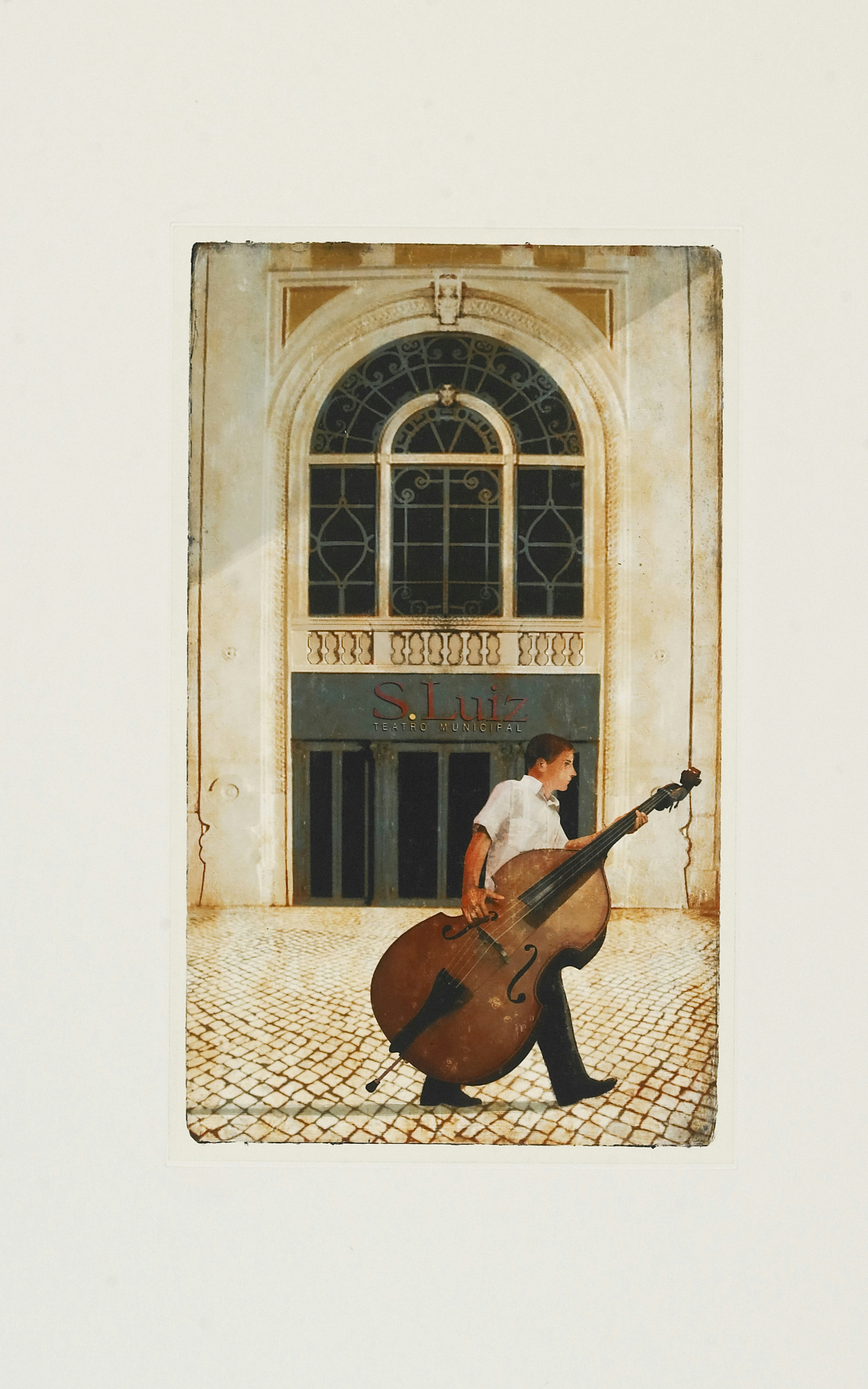 Mann mit Kontrabass geht vor dem Gebäude vorbei