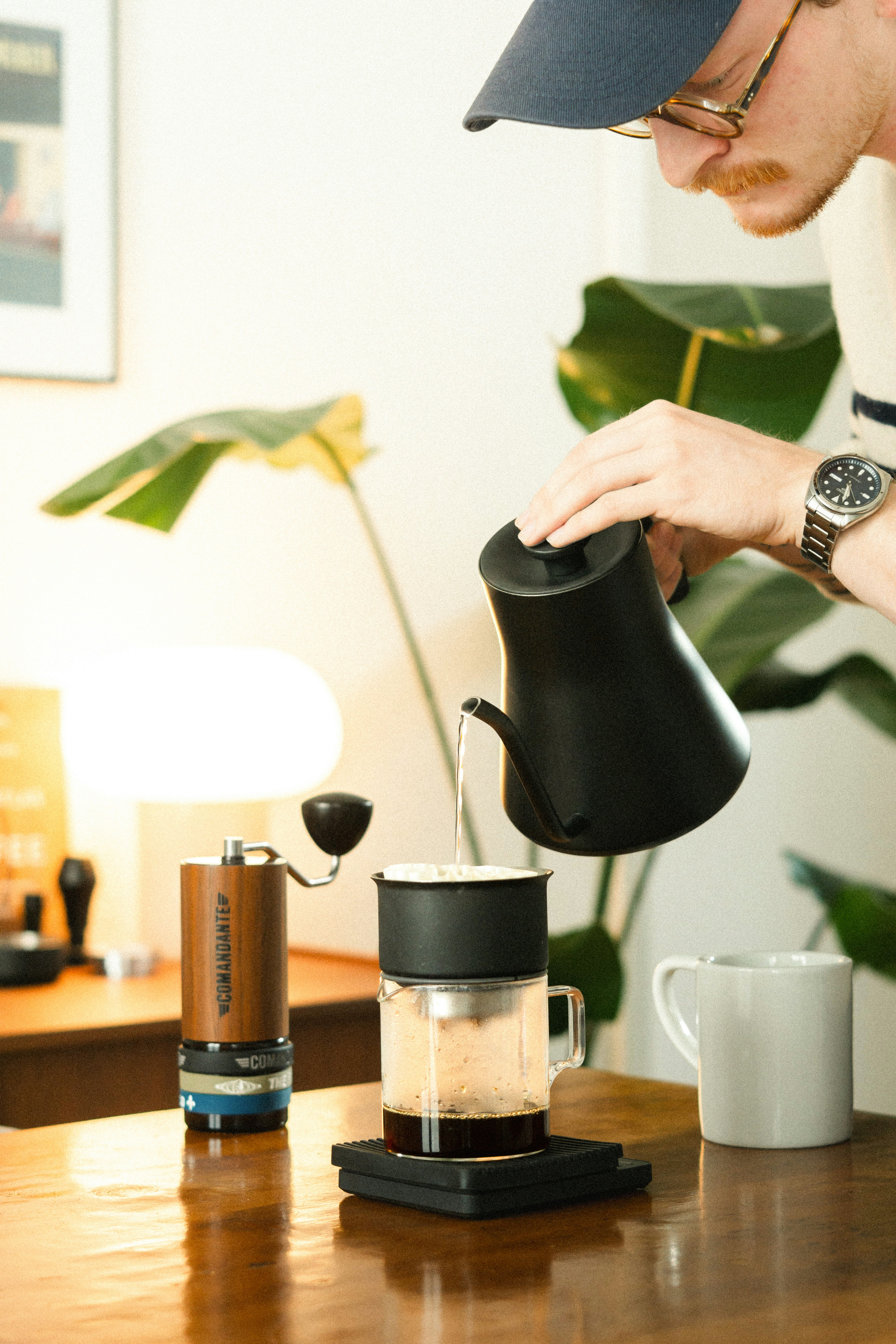 Man pours hot water into coffee for brewing.