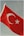 The turkish flag waves against a cloudy sky.