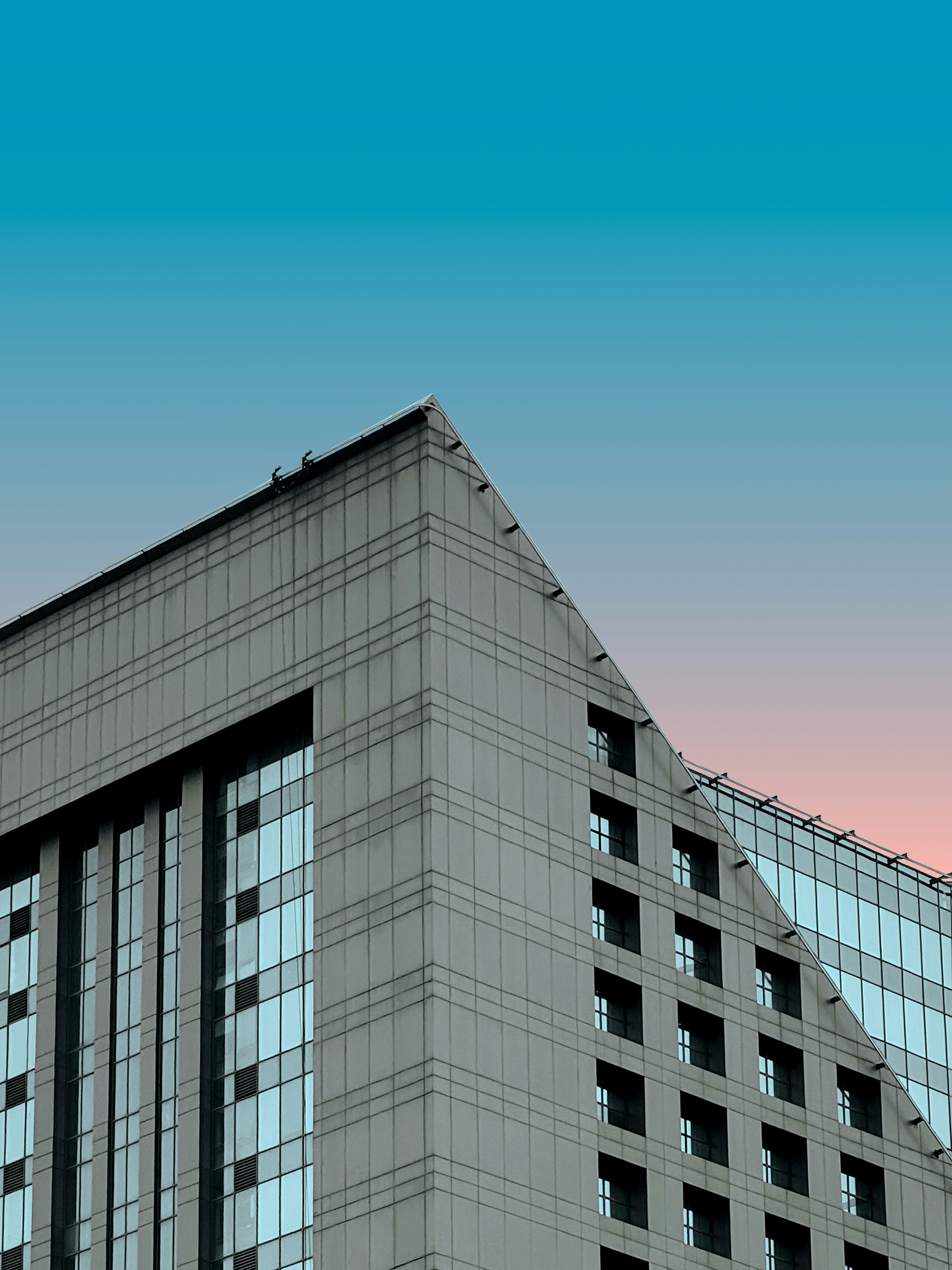 A modern building with a colorful sky.