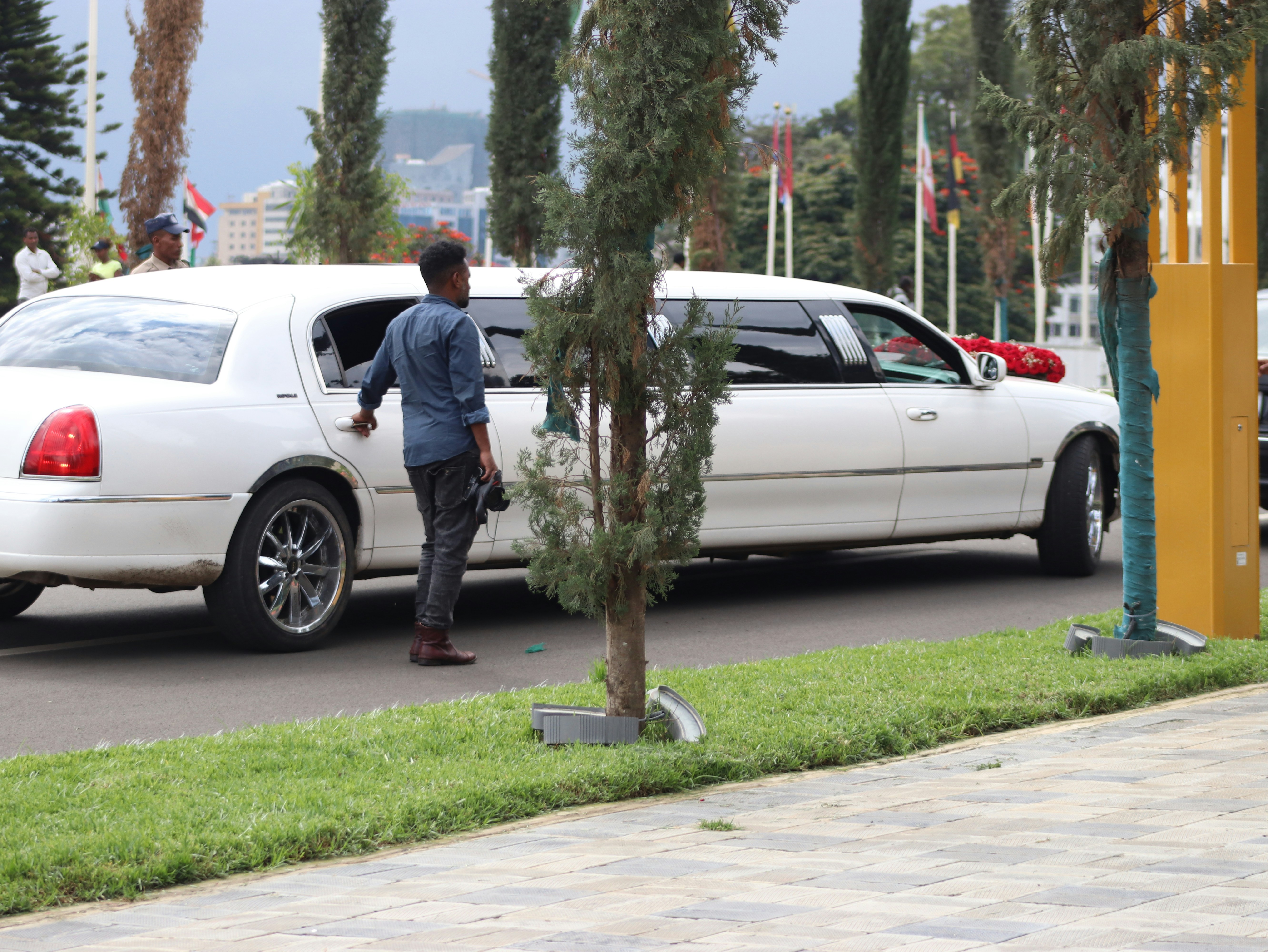 A man exits a white limousine.