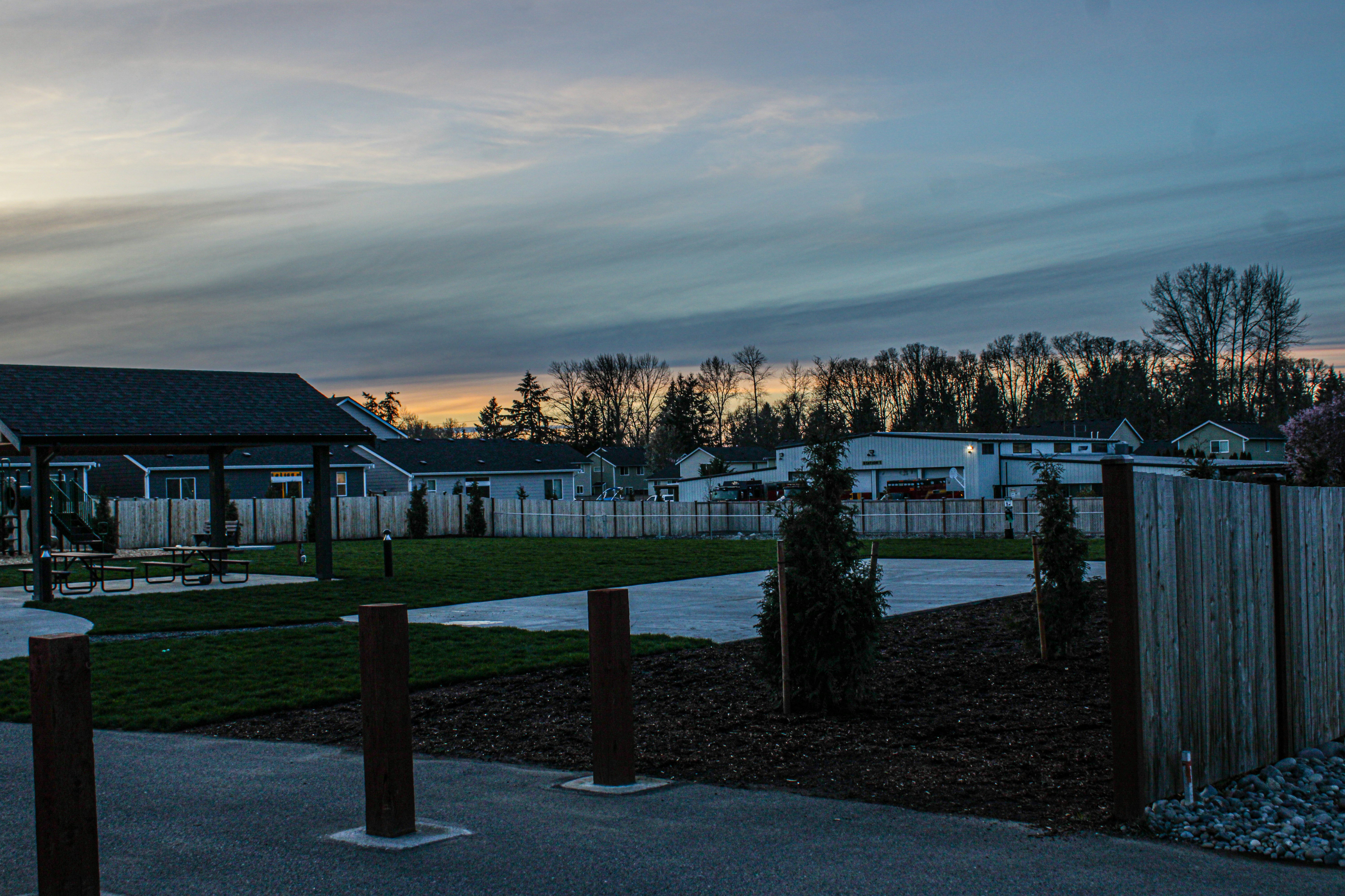 Die Dämmerung legt sich über ein Viertel mit einem Park.