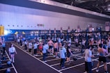 People are working out in a large indoor gym.