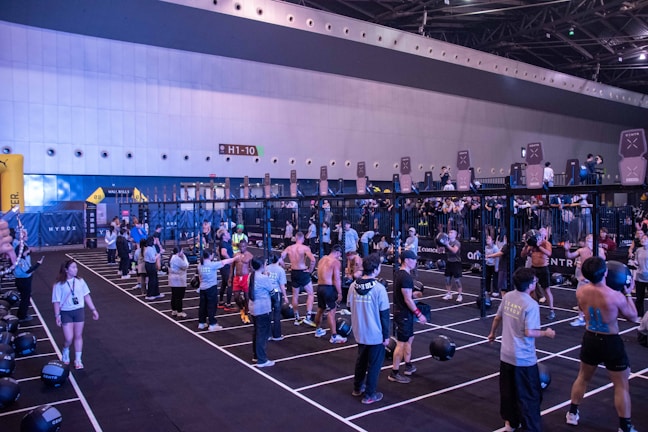 People are working out in a large indoor gym.