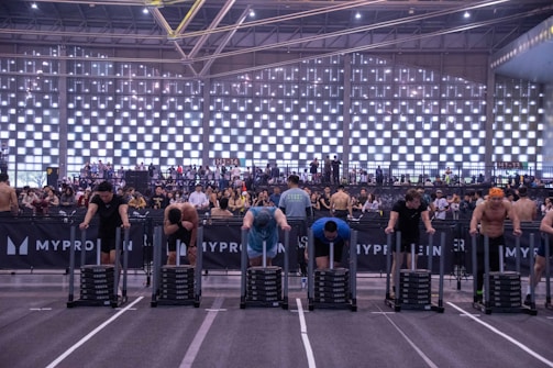 Athletes compete by pushing weighted sleds indoors.