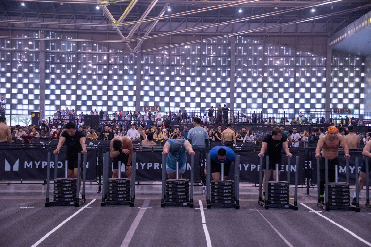 Athletes pushing weighted sleds at an indoor competition
