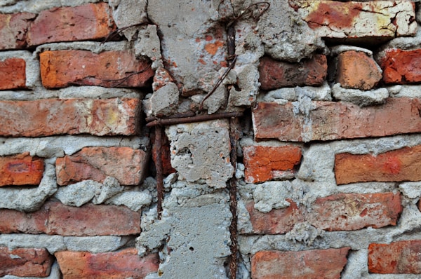 Broken brick wall with exposed rebar.
