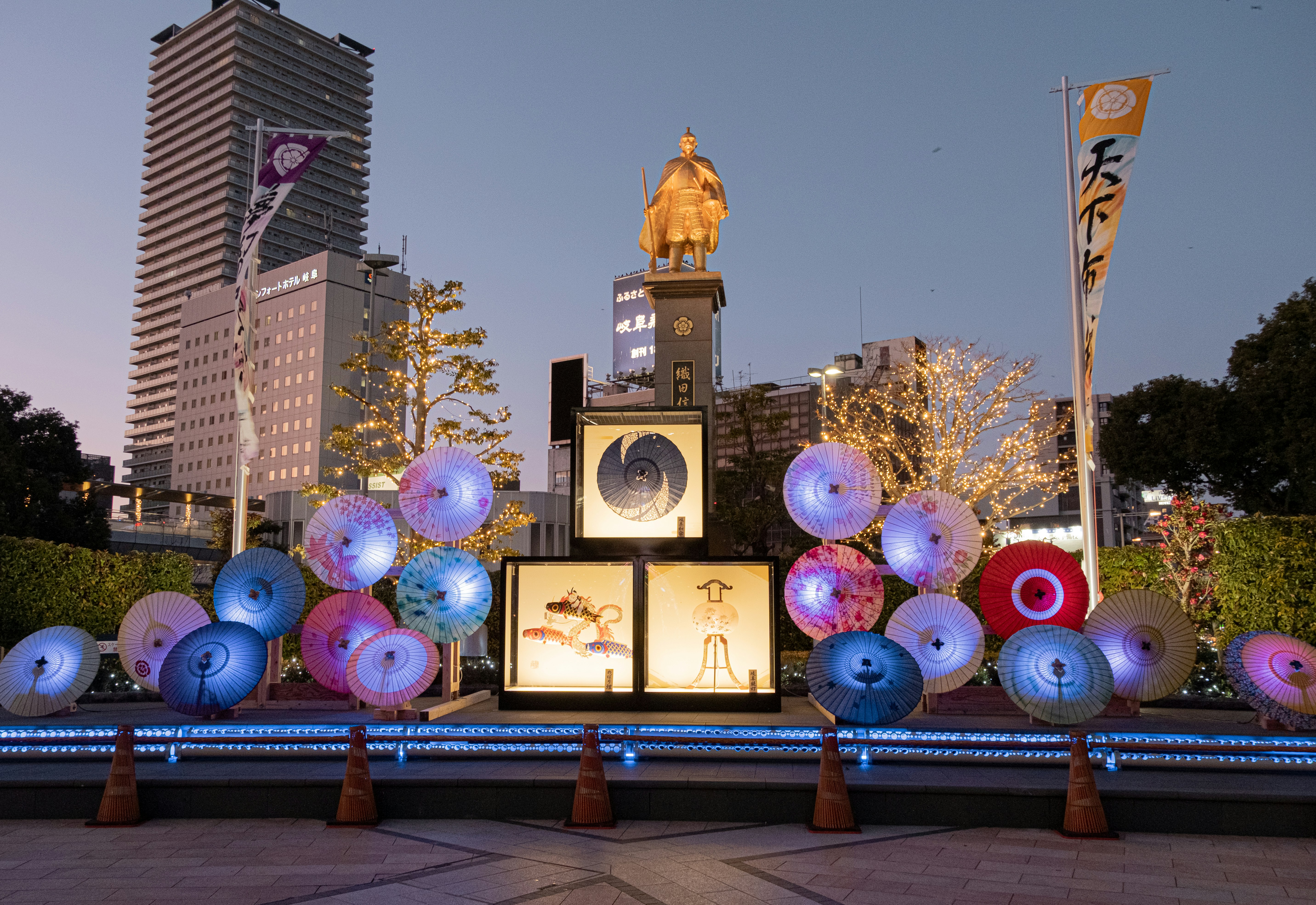 Nighttime scene features balloons and a golden statue.