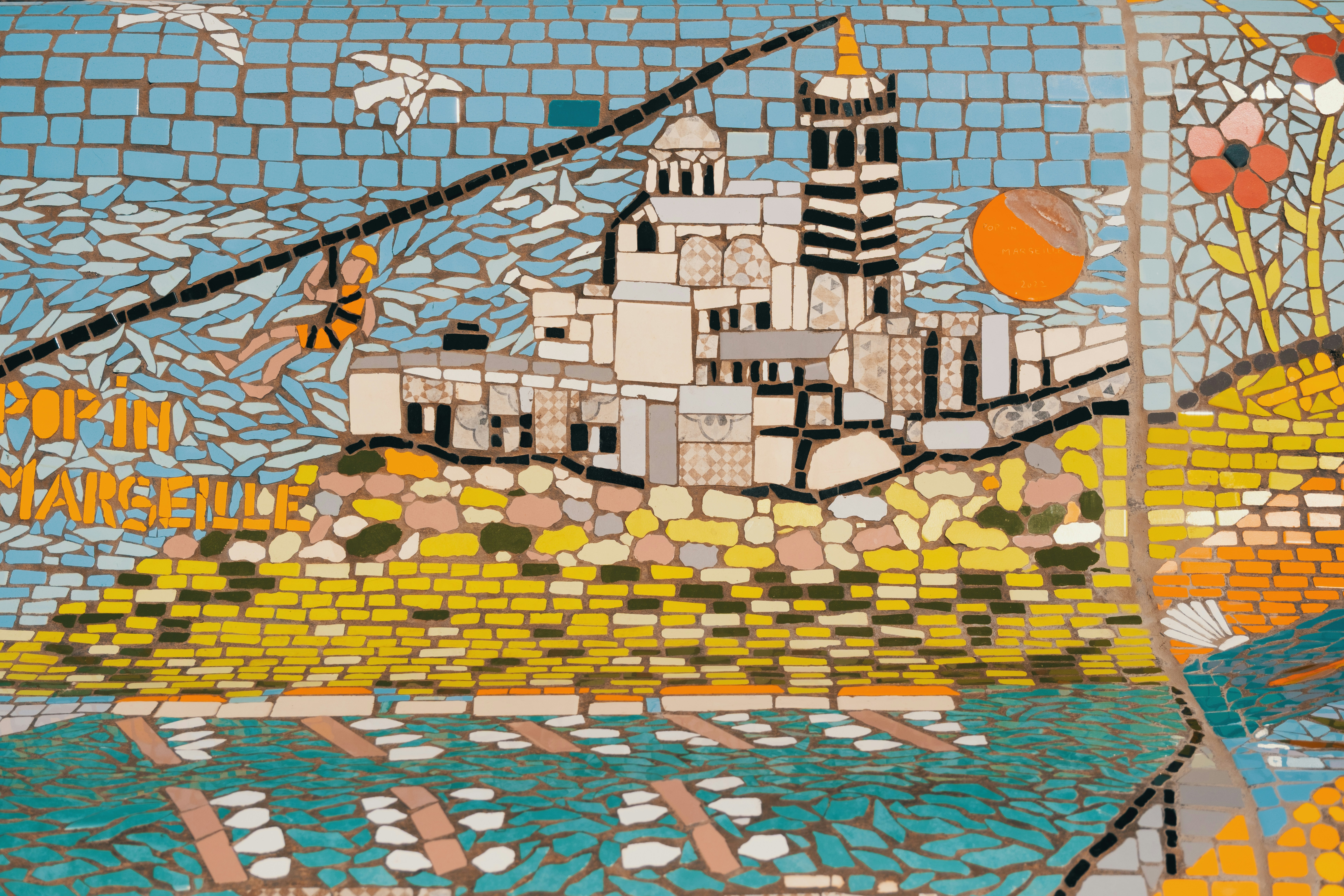 Mosaic art depicts buildings and a zipline.