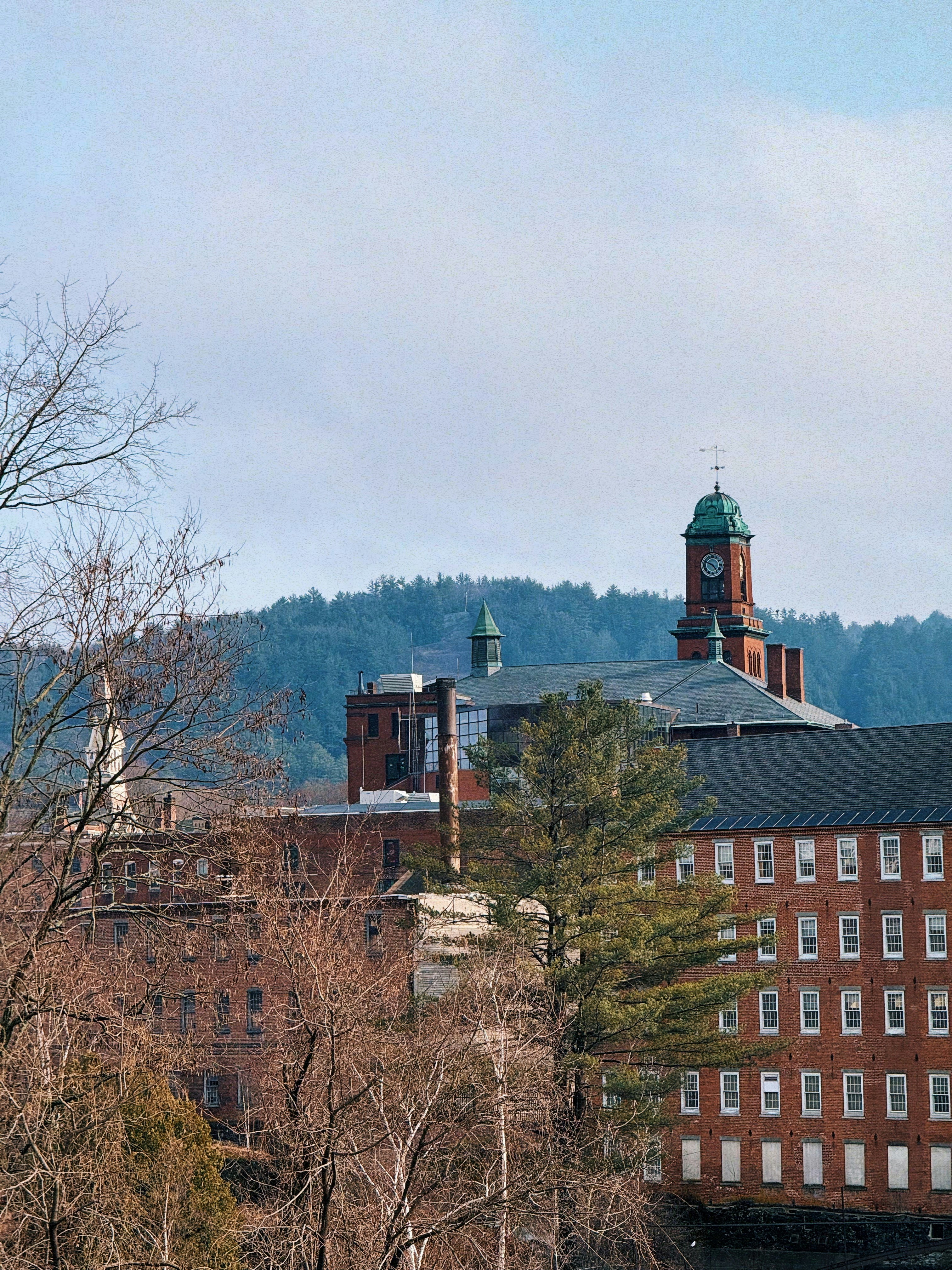 Old brick buildings sit below a cloudy sky.