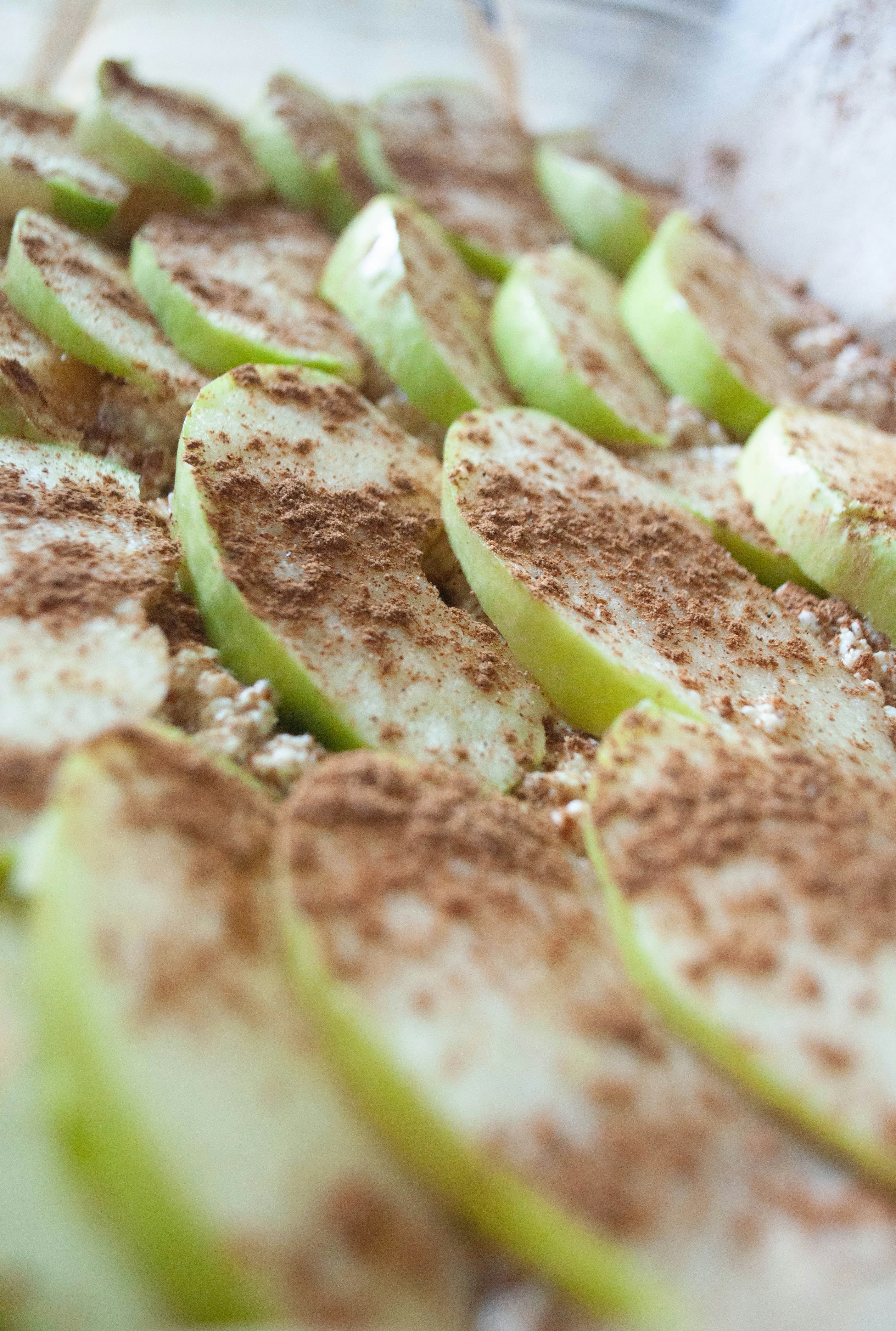 Sliced green apples sprinkled with cinnamon.