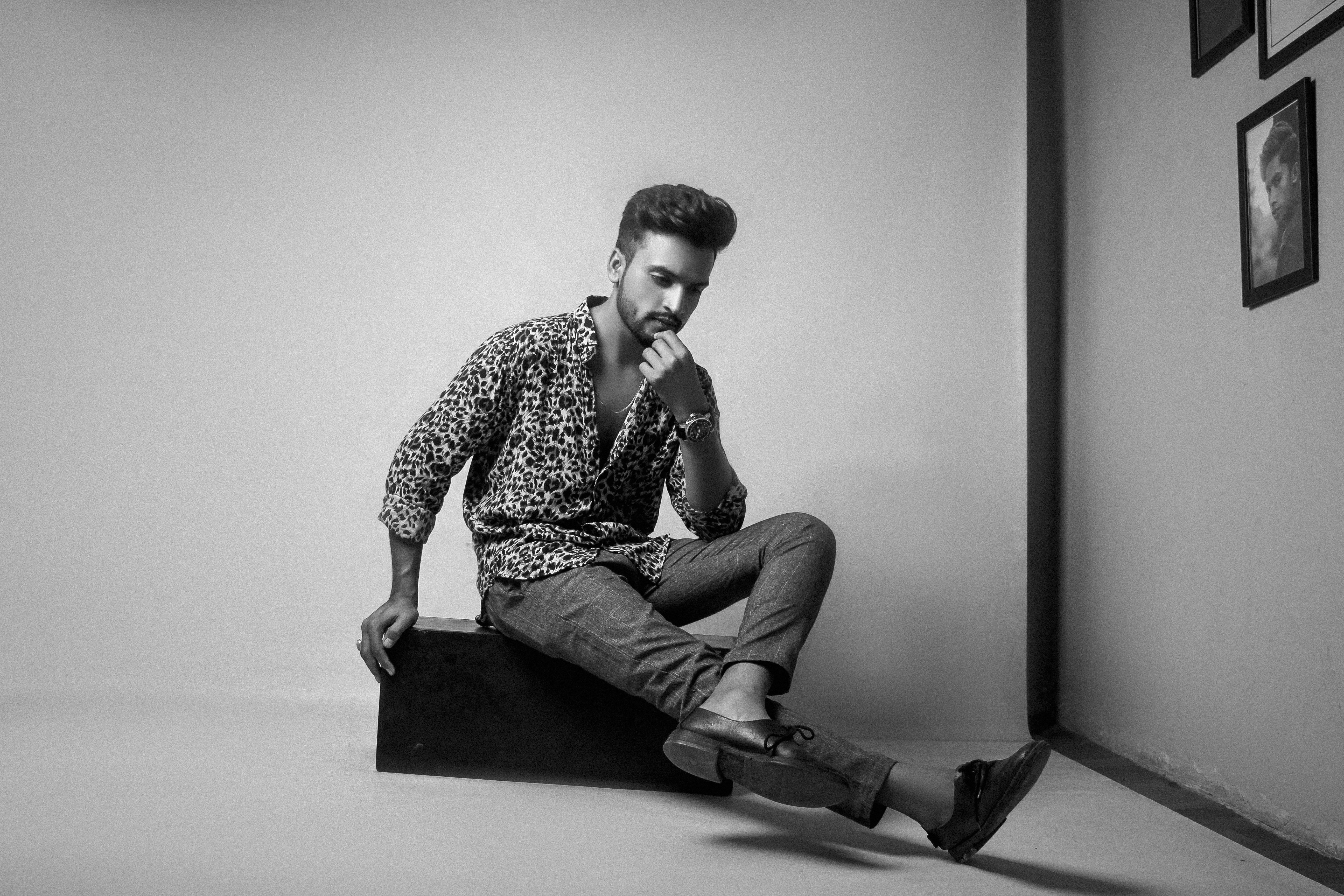 Man poses thoughtfully in black and white.