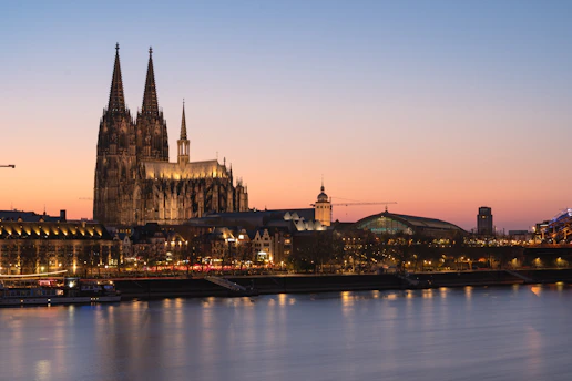Cologne cathedral at dusk, reflected in the water.