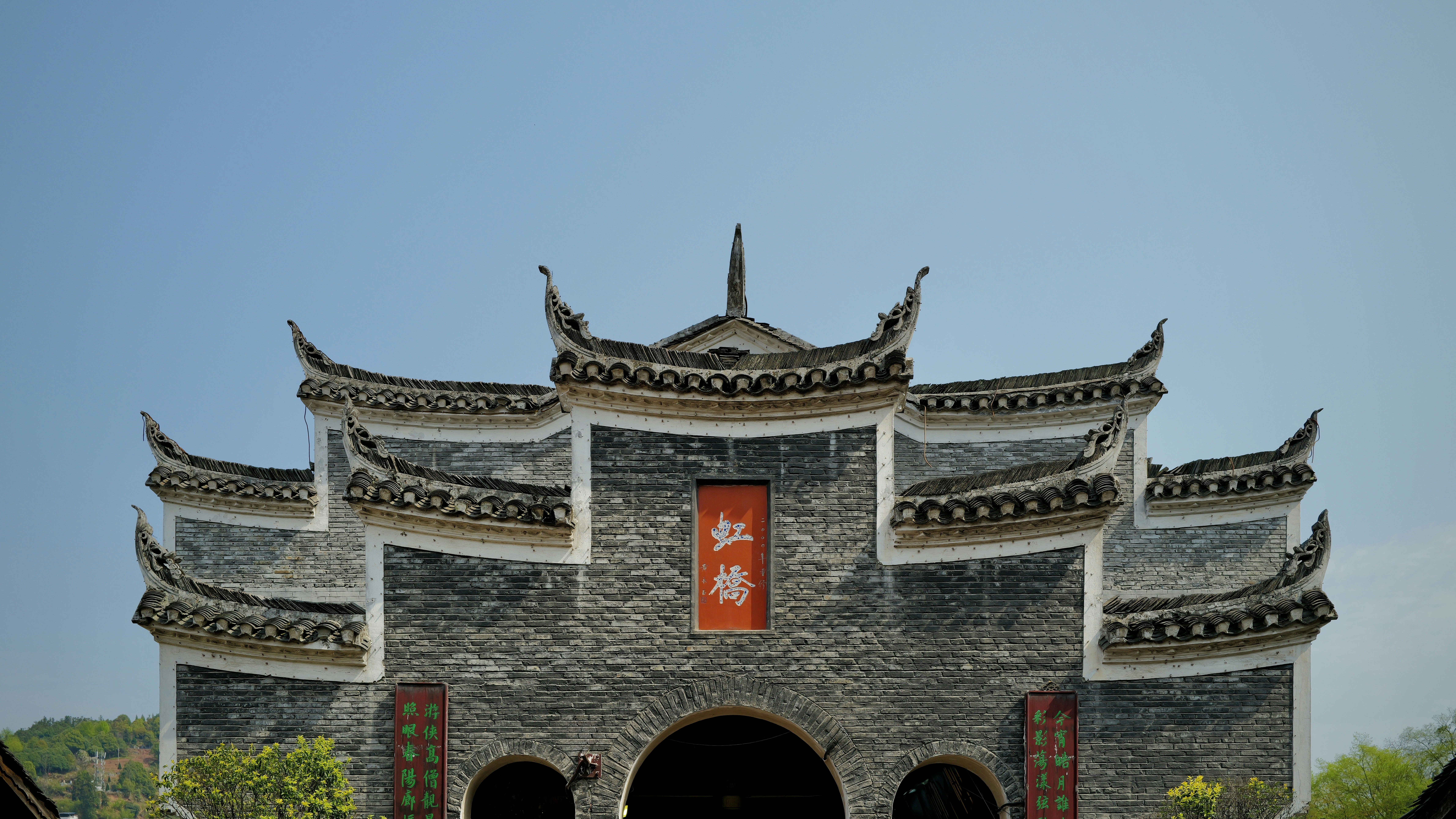 An ornate chinese archway stands against a clear sky.
