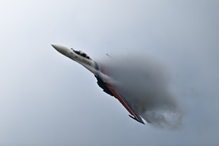 A fighter jet creates a vapor cone.