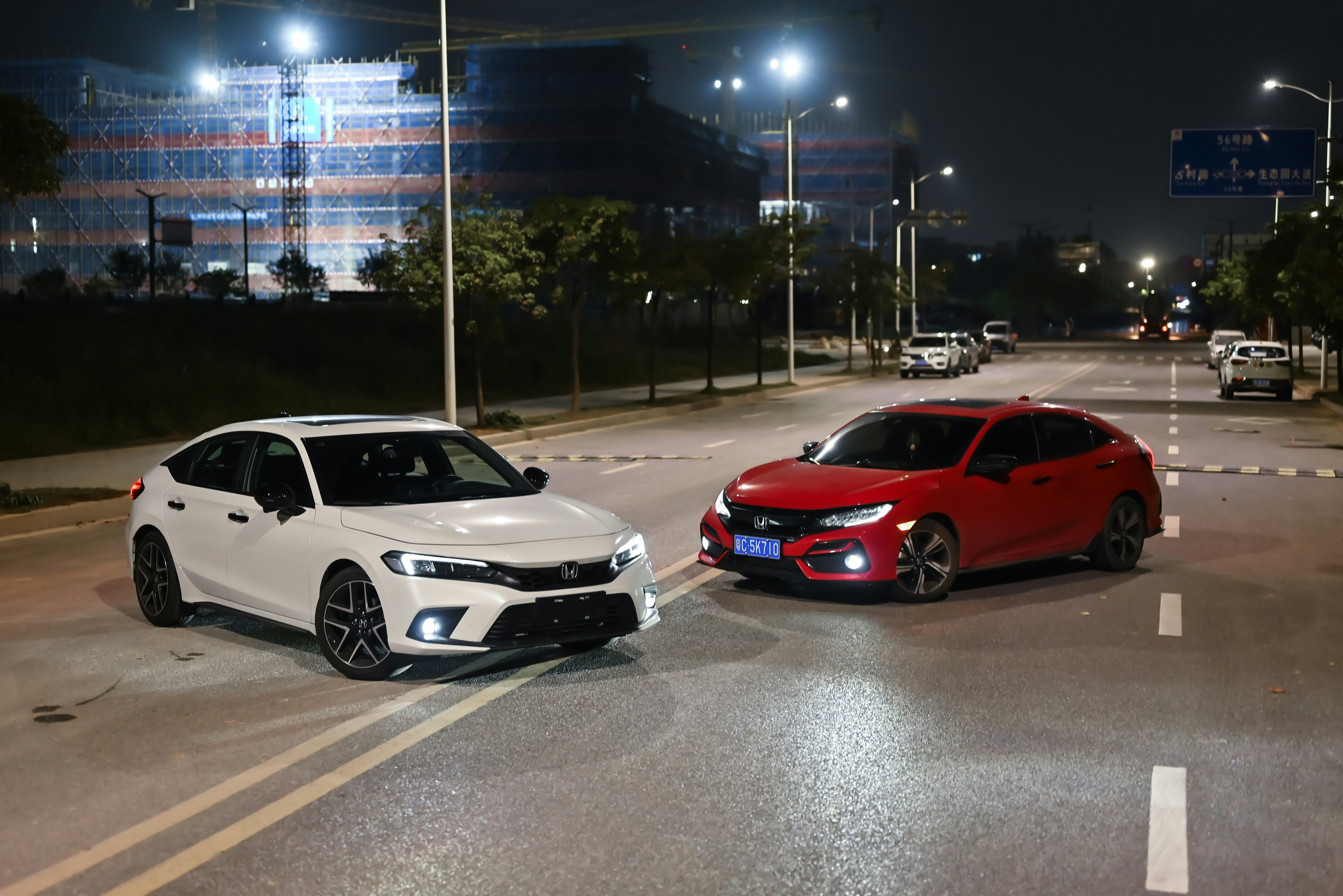 Dois carros estão estacionados em uma estrada à noite.