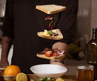 A sandwich is being assembled in mid-air.