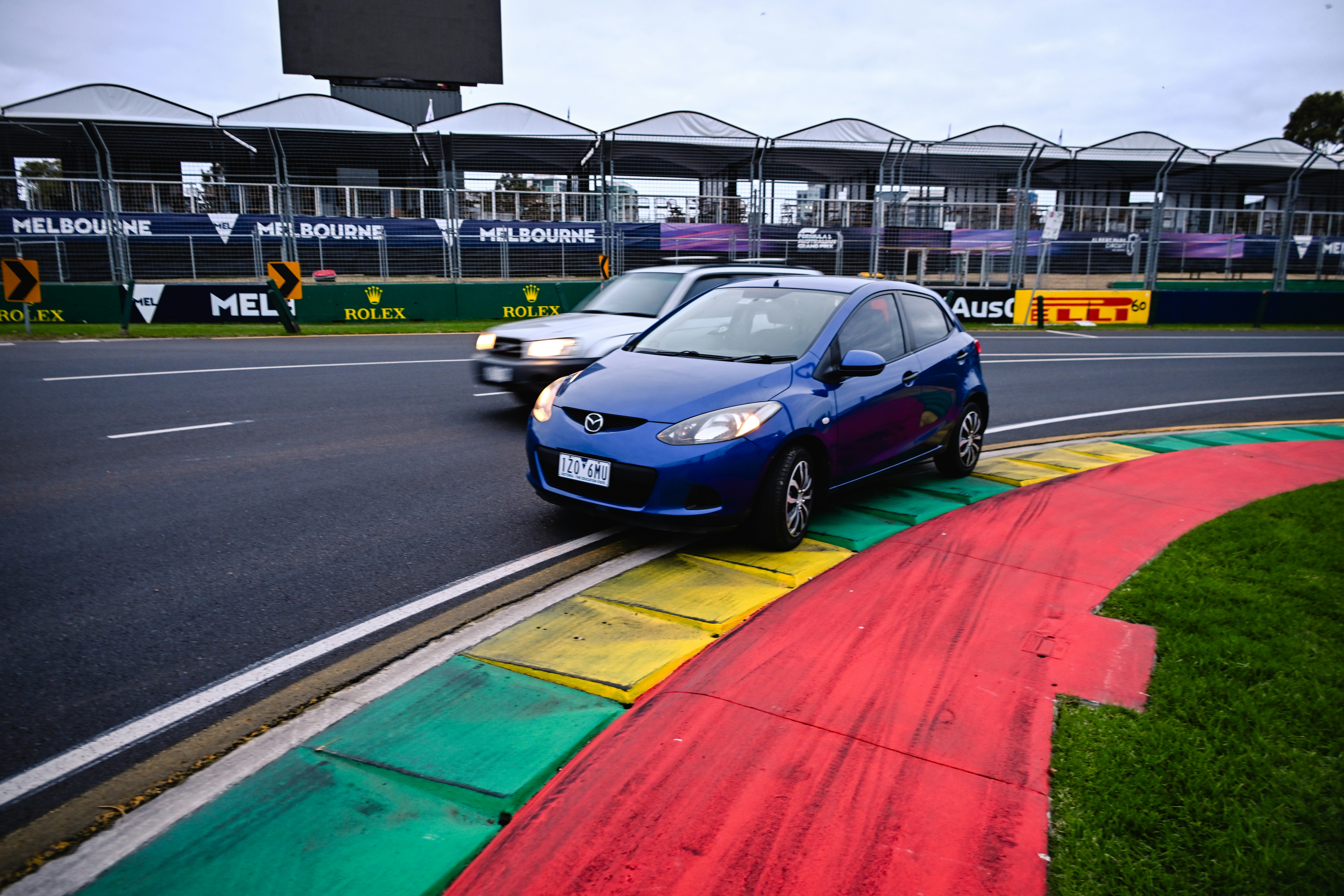 Dois carros dirigindo em uma curva de pista de corrida.