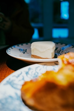 Cheesecake and pastries are on pretty plates.