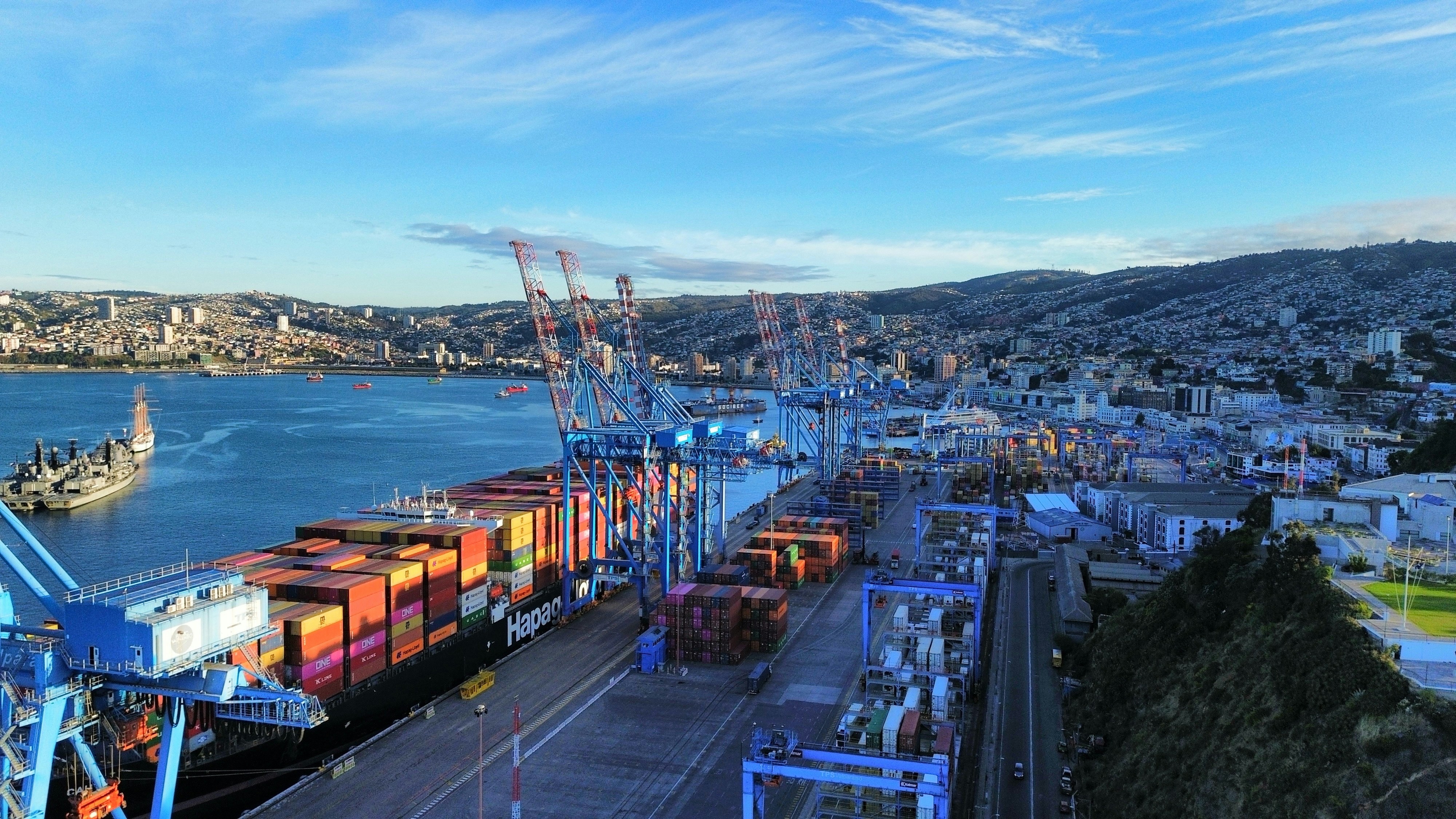 A panoramic shot of a modern port in Chile with large cargo ships, subtly showing its trade potential and global connectivity.