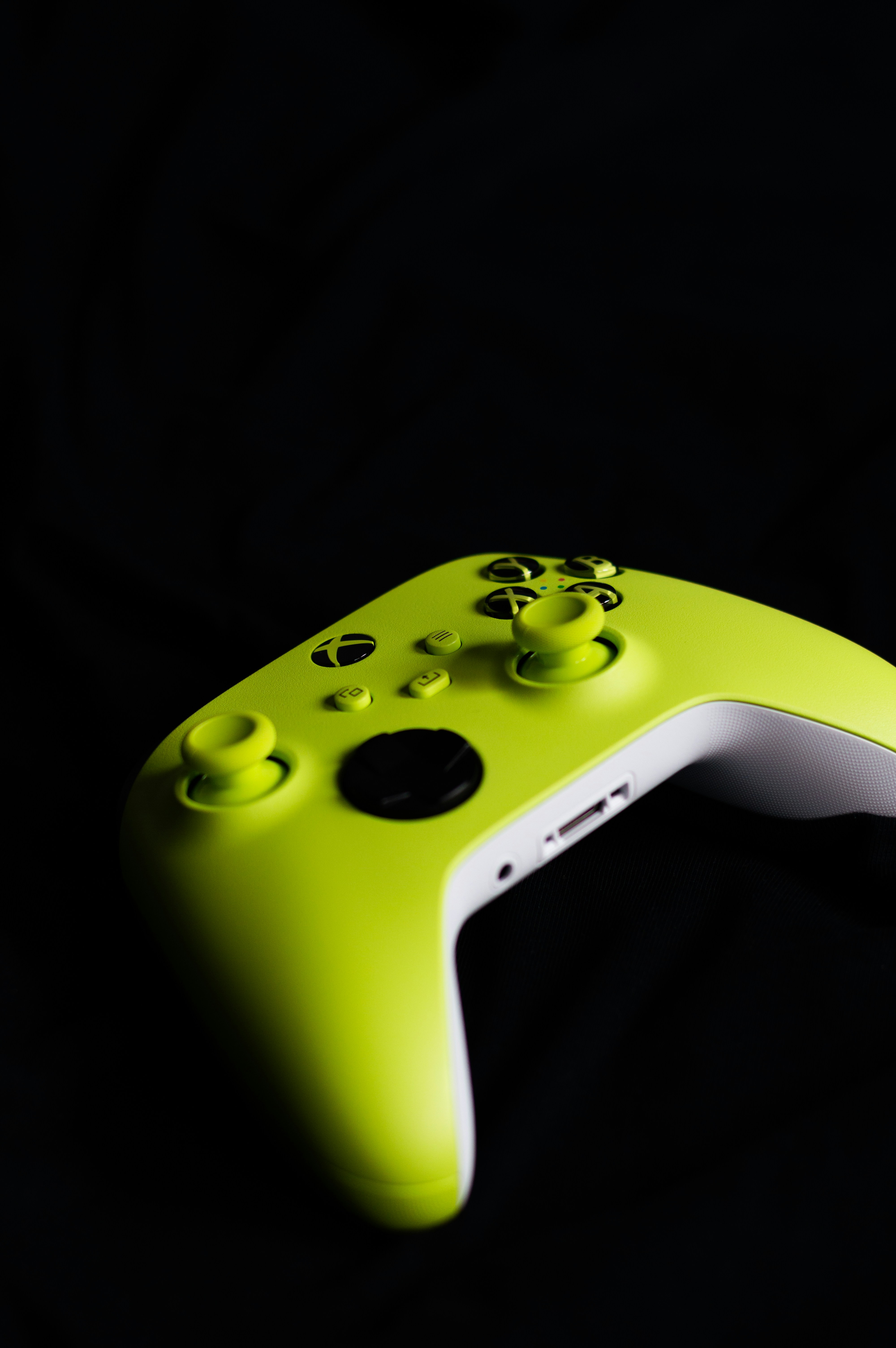 Ein leuchtend grüner Gaming-Controller sitzt auf Schwarz.