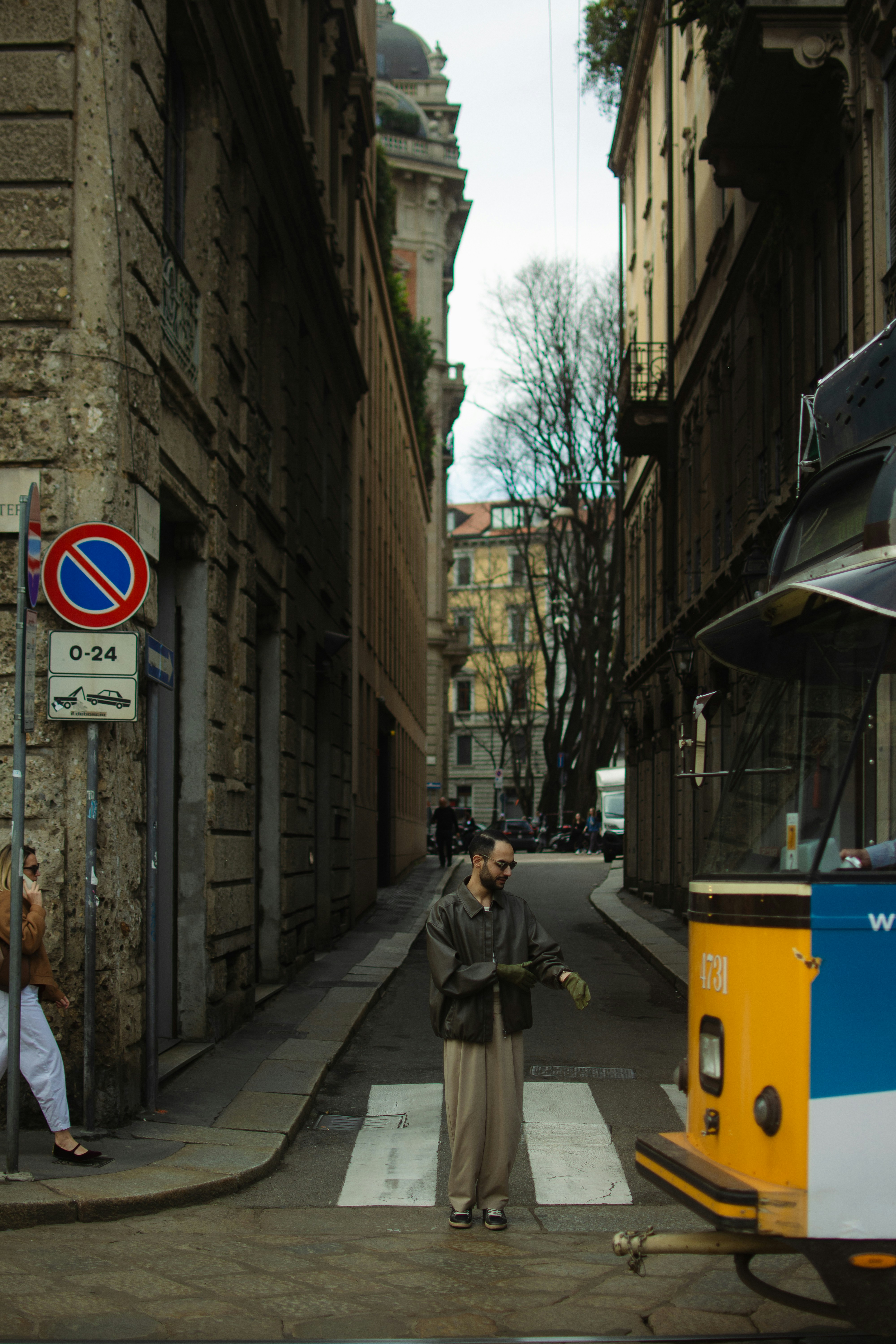 A person stands on a crosswalk in the city