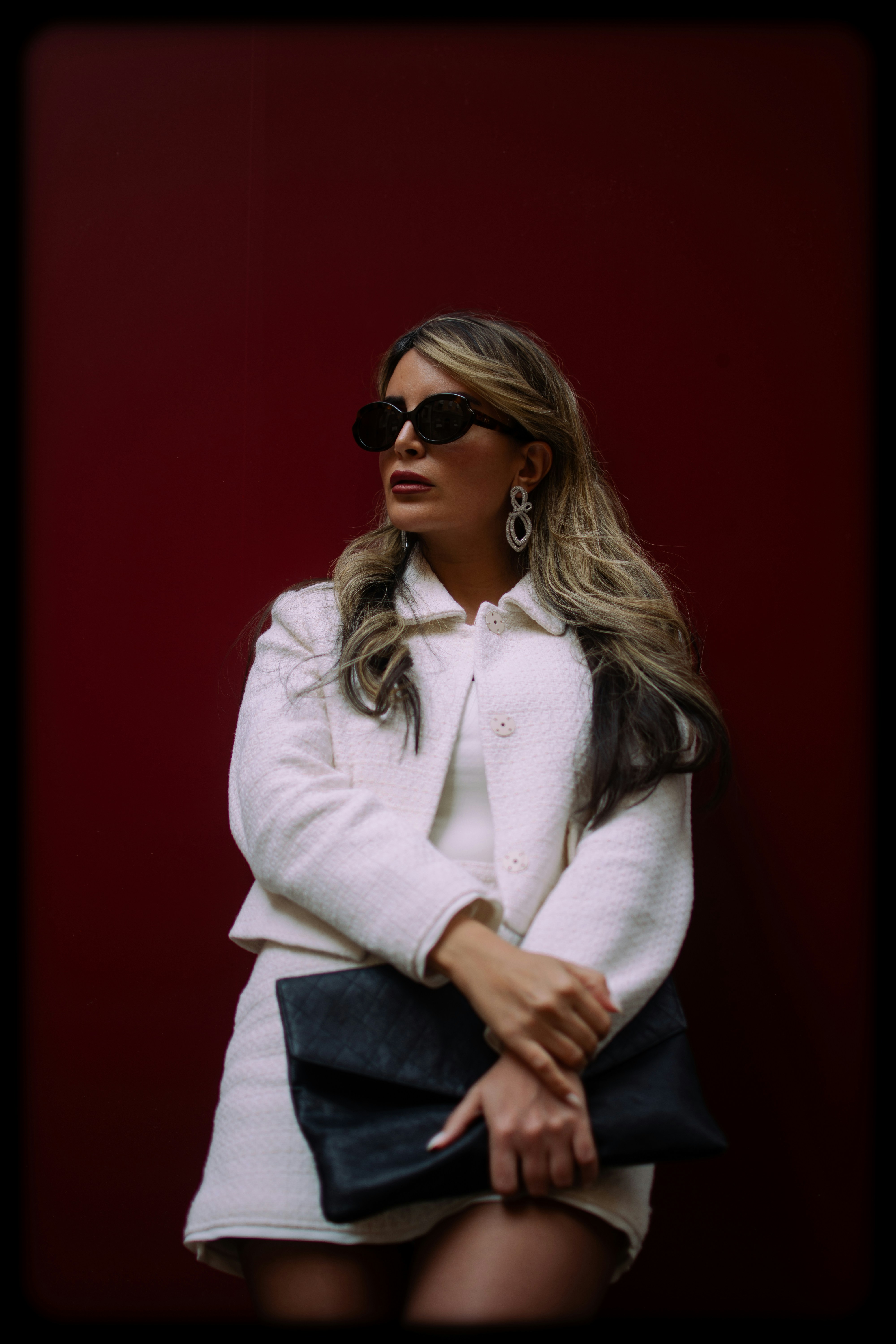 Woman poses in a stylish outfit, looking away.