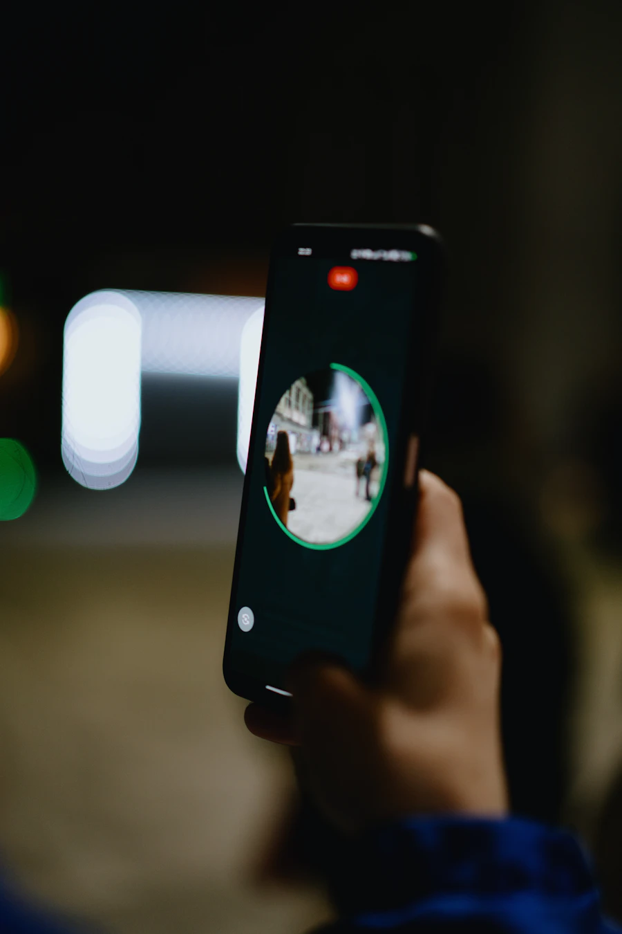 Main enregistrant une scène sur un smartphone