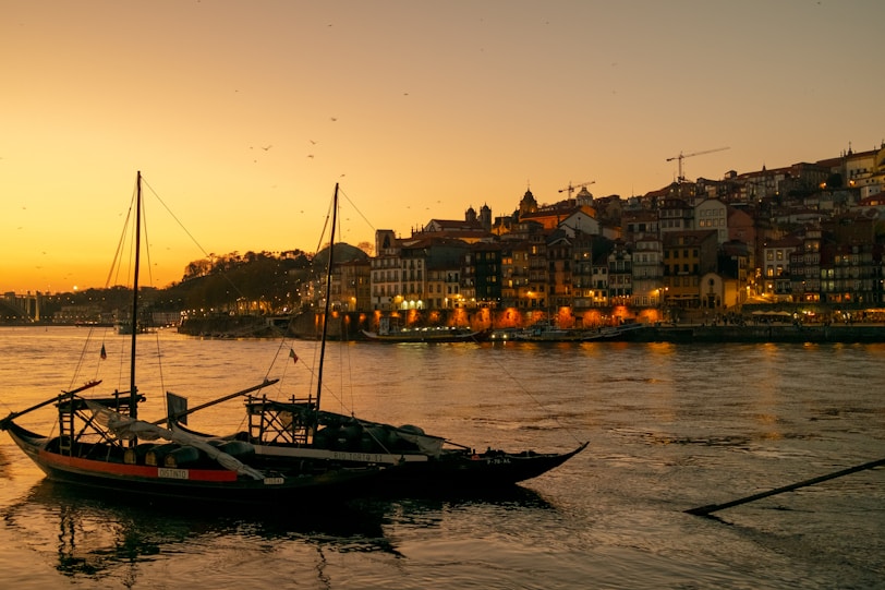 Boats float on a river at sunset.