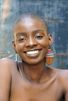A smiling woman poses with earrings.