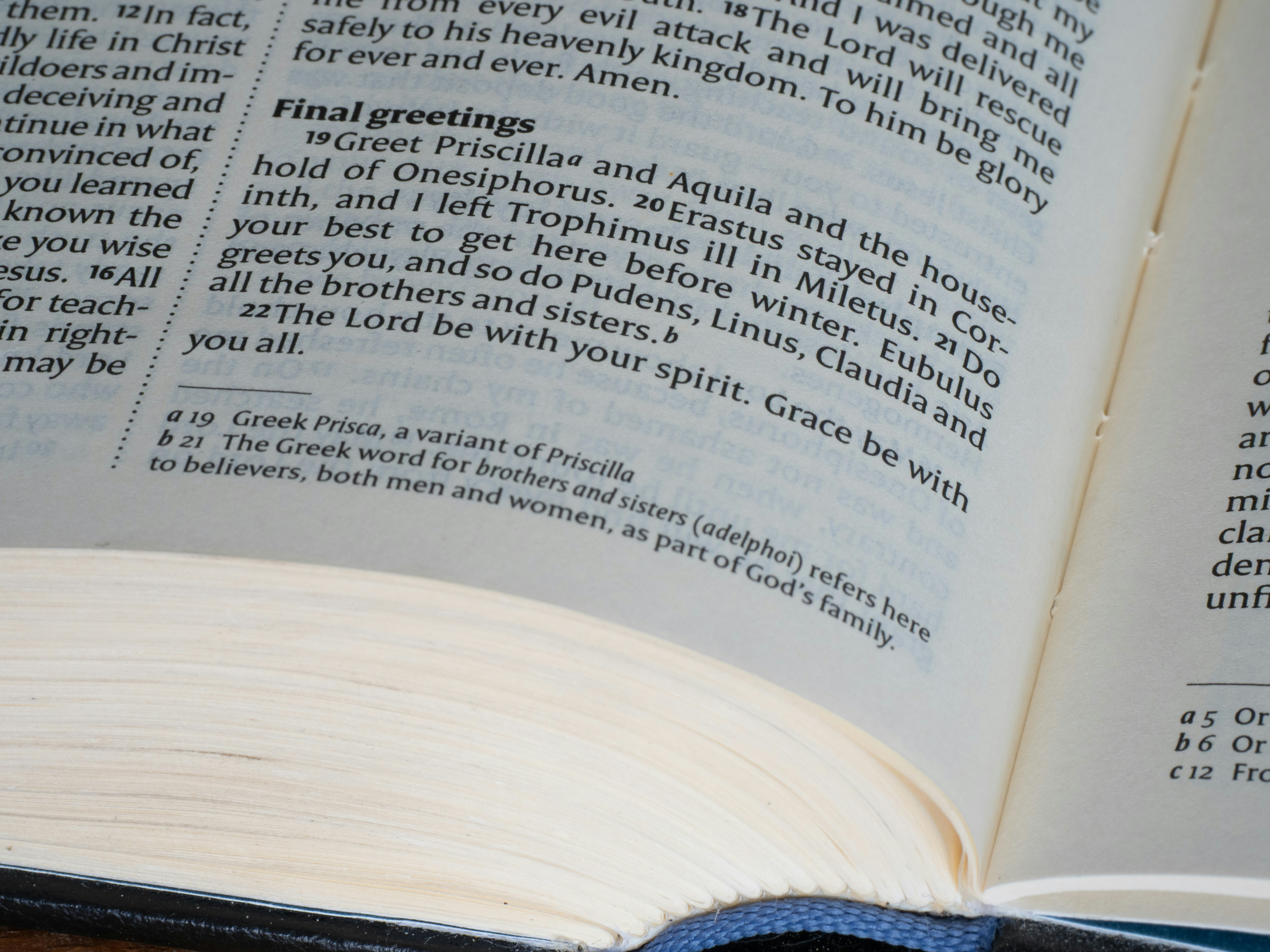 Open bible pages showing scripture about greetings.