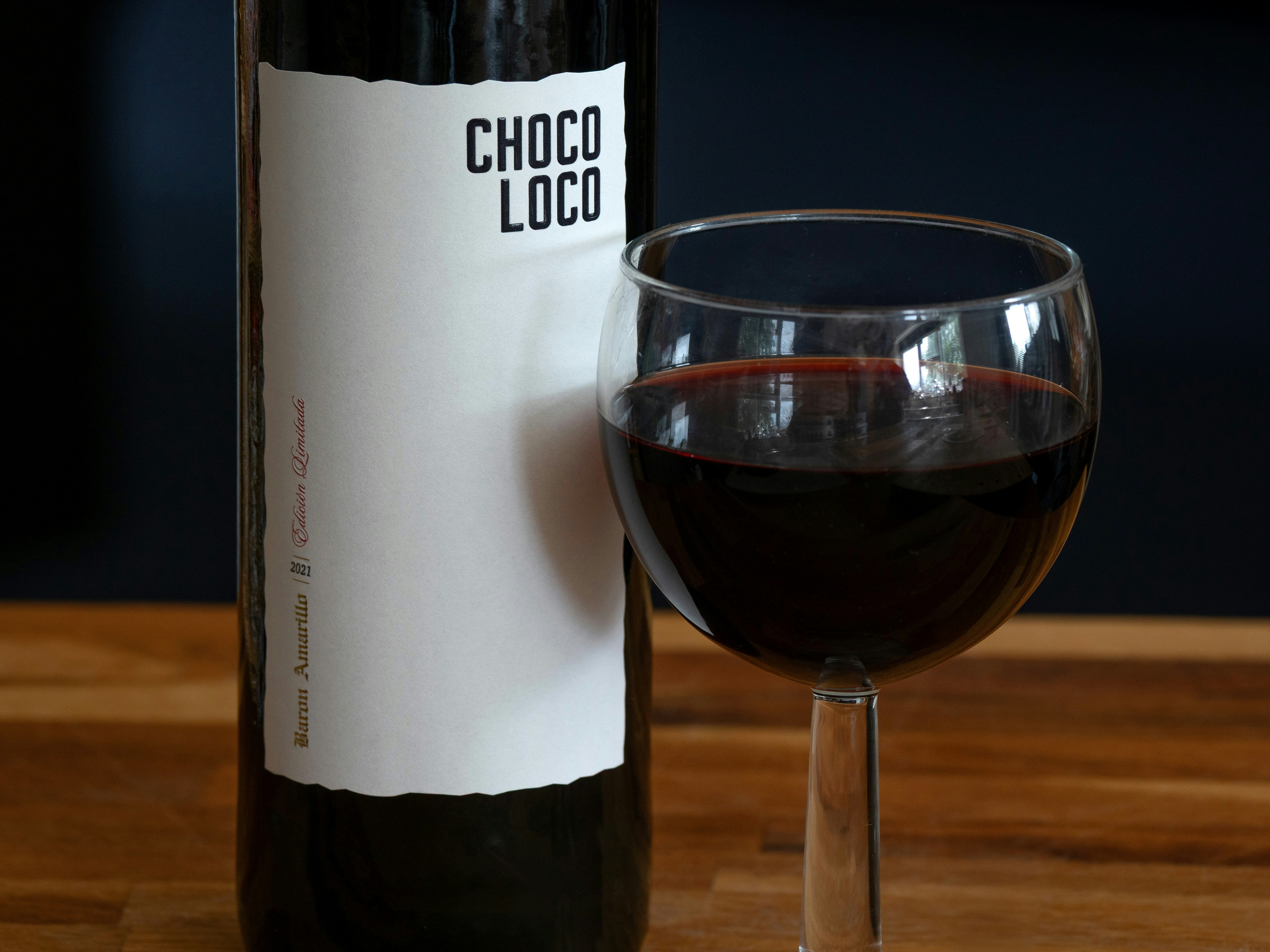 Wine bottle labeled "choco loco" with a glass.
