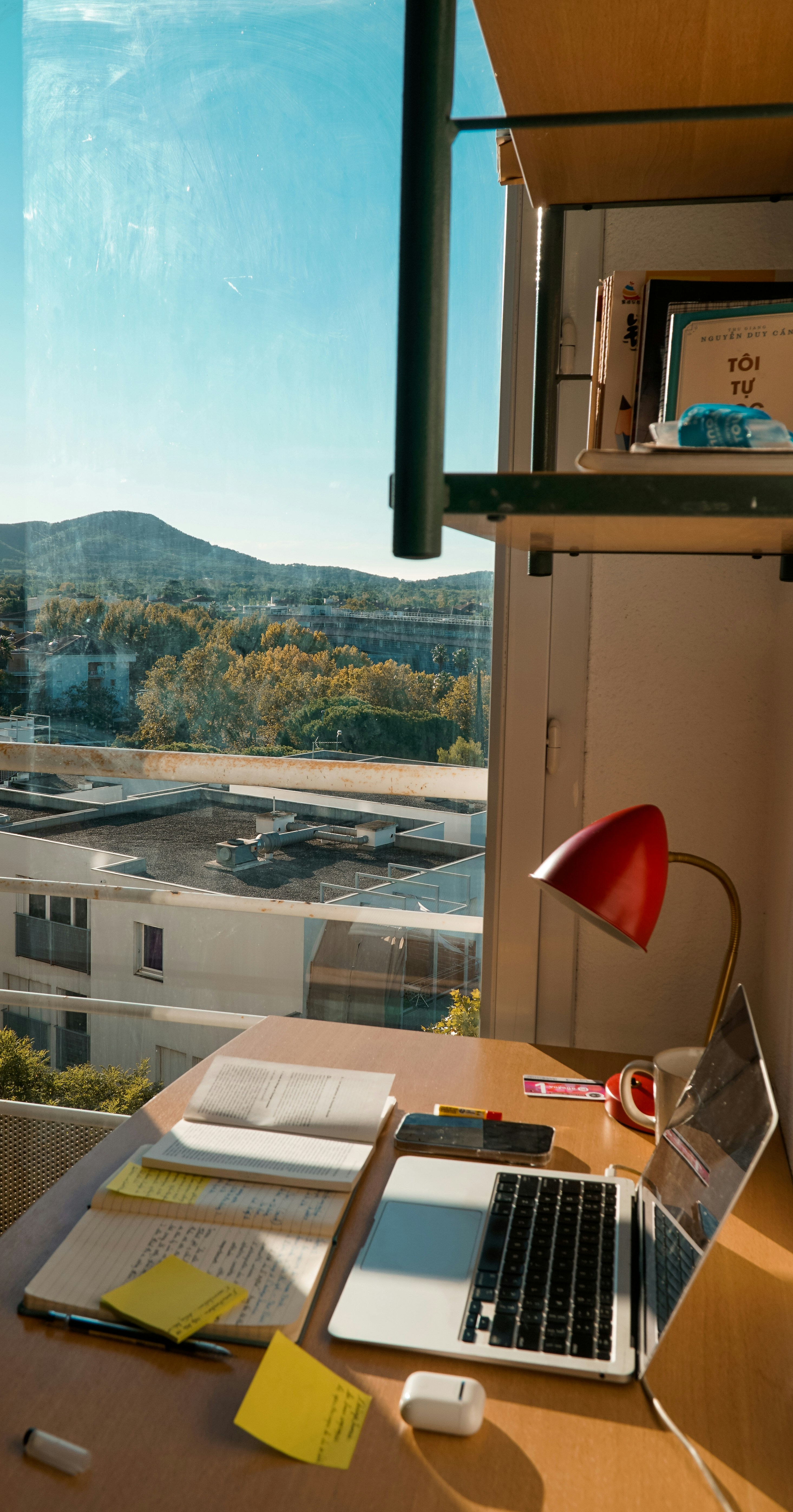 A desk with laptop, looking over a scenic view.