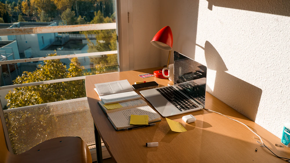 Espace de travail lumineux avec un ordinateur portable près d’une fenêtre