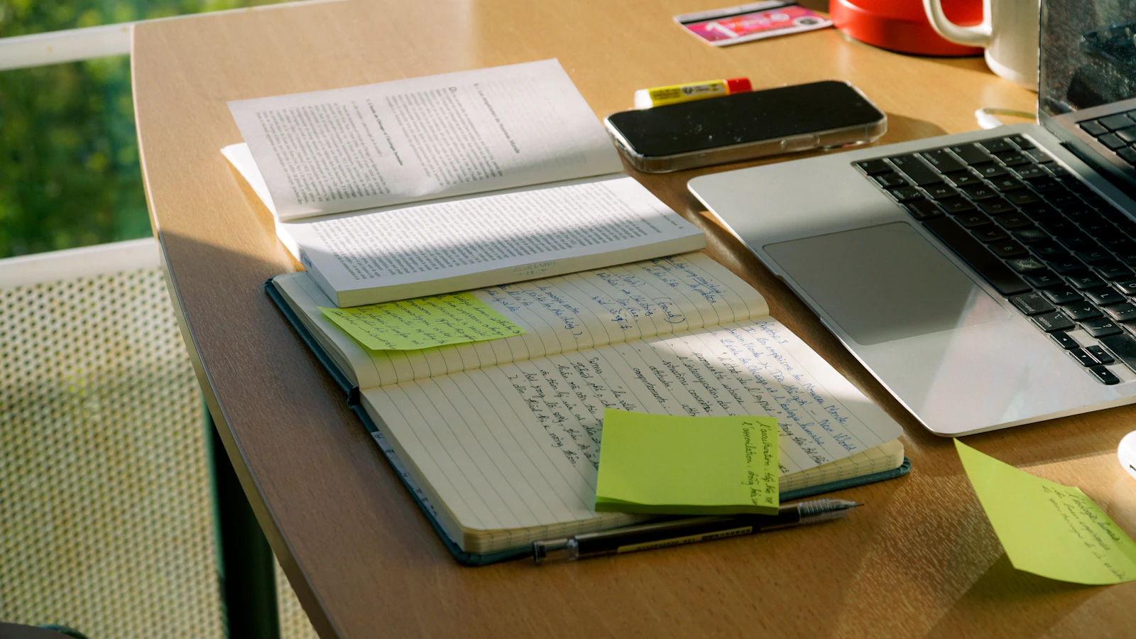 Laptop, notebooks and written notes on a desk representing the process of transforming PLR source material into affiliate content