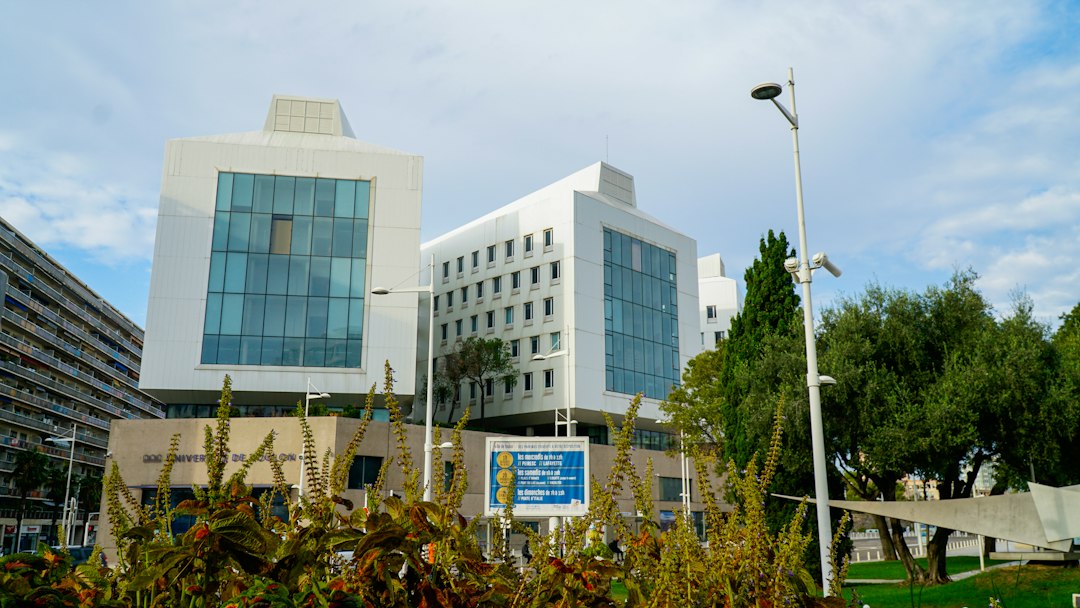 Modern white buildings stand under a cloudy sky