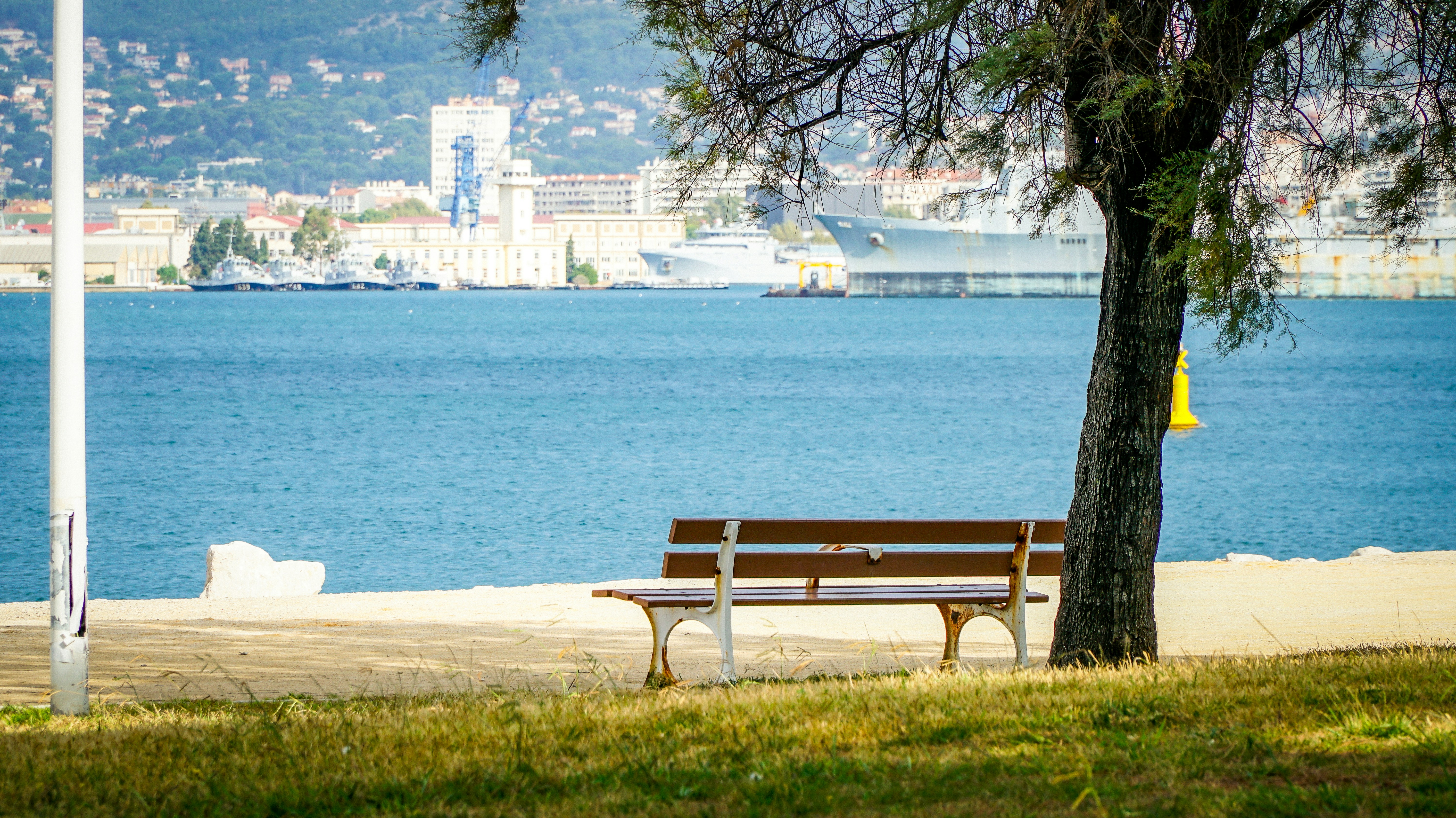 A peaceful park bench faces the blue ocean.