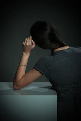 A woman leans on a surface.