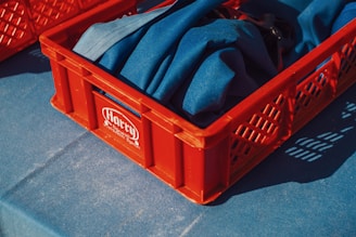 Red crate containing blue cloth.