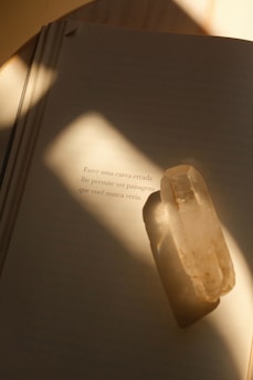Open book with a crystal, lit by sunlight.
