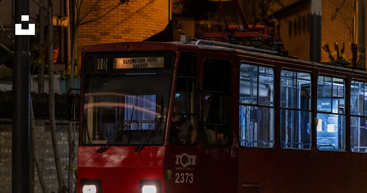 A red tram illuminated in the night. photo – Free Human Image on Unsplash