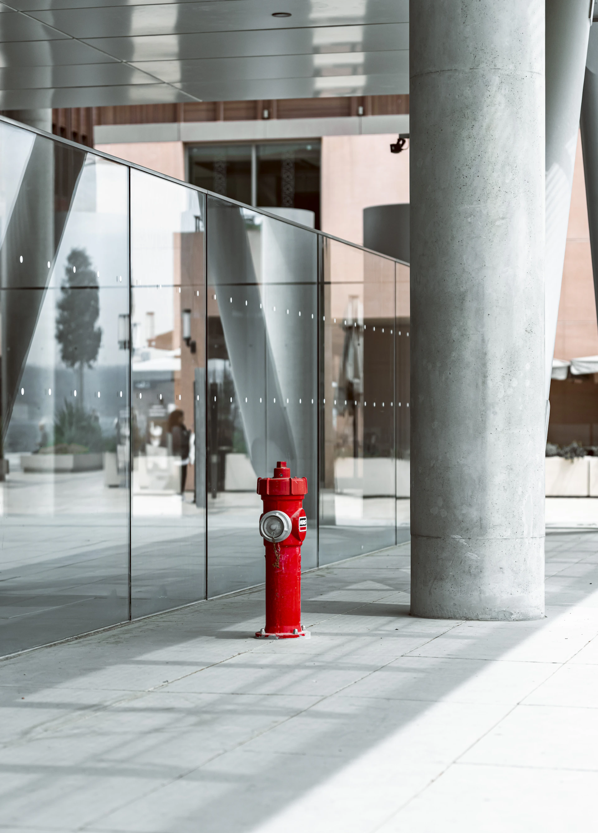 A bright red fire hydrant in a modern setting.