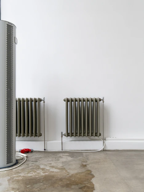 Two radiators stand against a white wall.