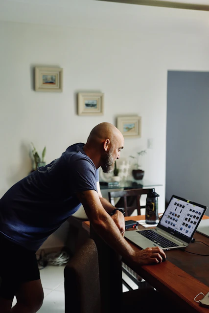 Man works on laptop at home.