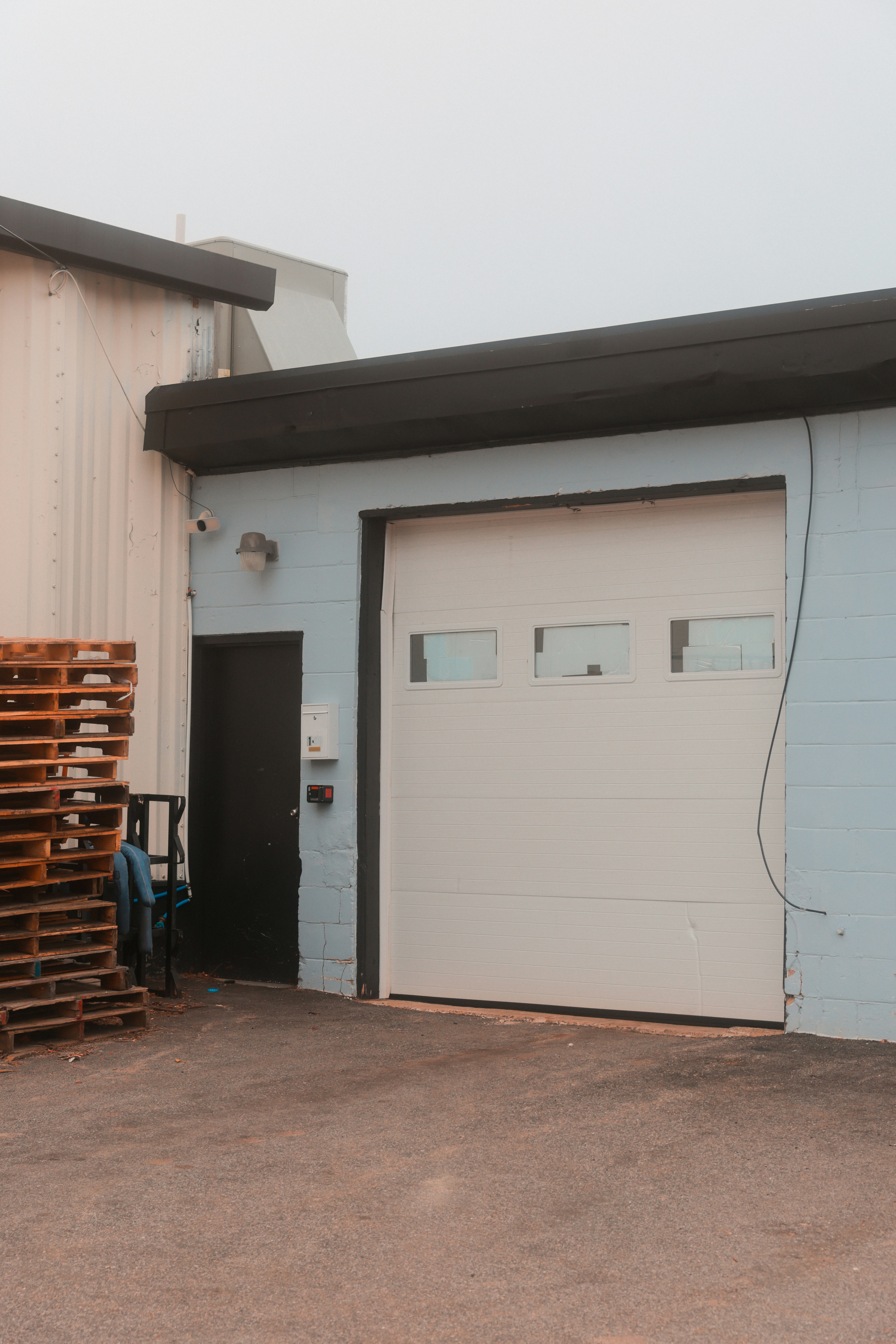 An industrial building with a closed garage door.