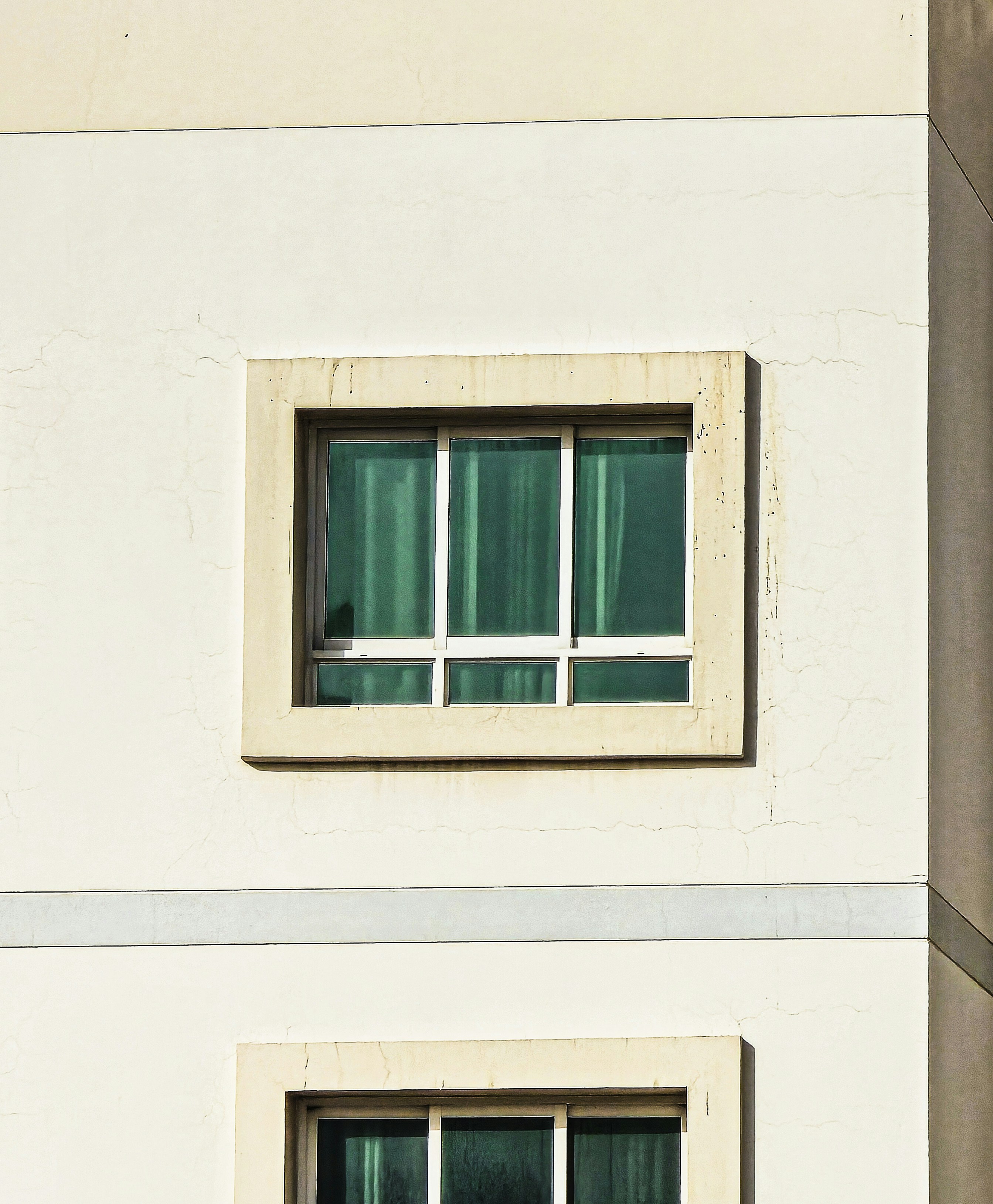 Windows on a white building in daylight.