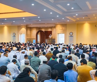 People praying together inside of a mosque.