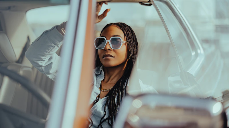 Stylish sugar baby leaning against a luxury car in Canada